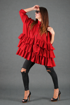 Woman wearing a red ruffled dress against a gray background