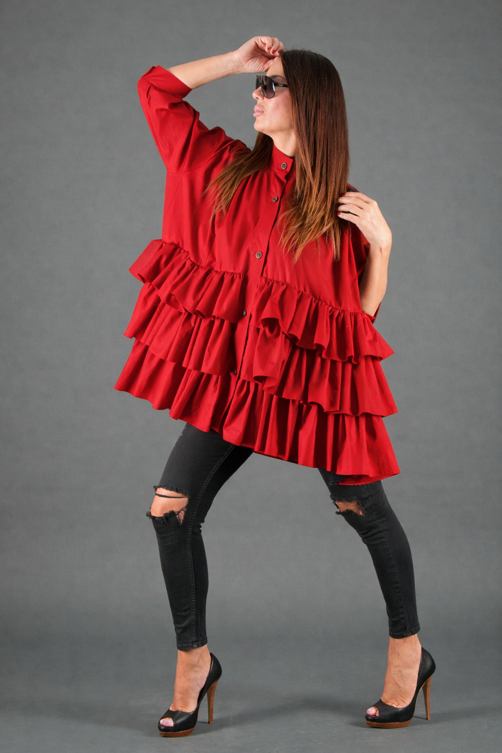 Woman wearing a red ruffled dress against a gray background
