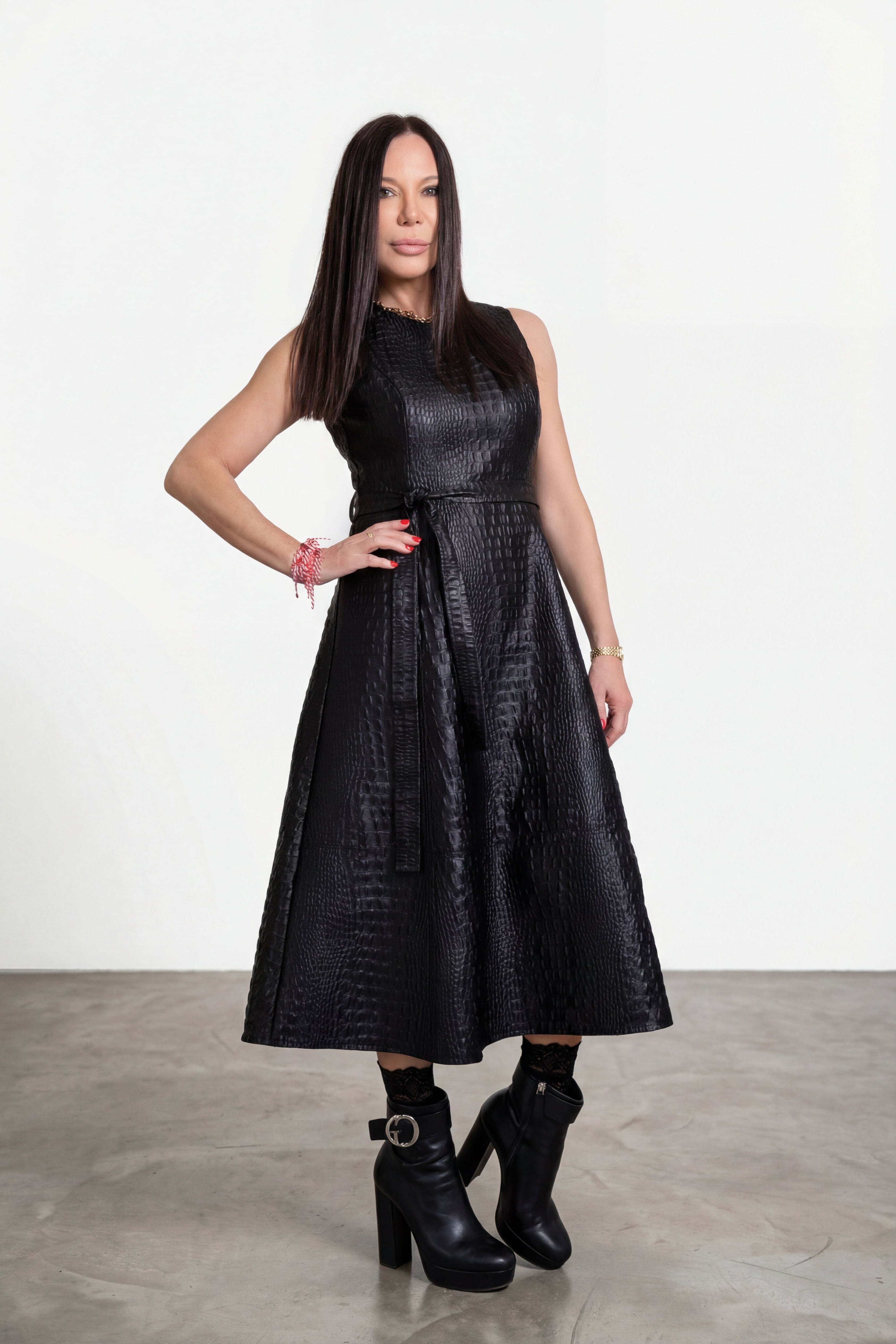 Woman wearing a black dress with a textured pattern on a white background